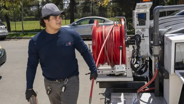 E-Drains technician preparing hydro jetting equipment for a plumbing service.